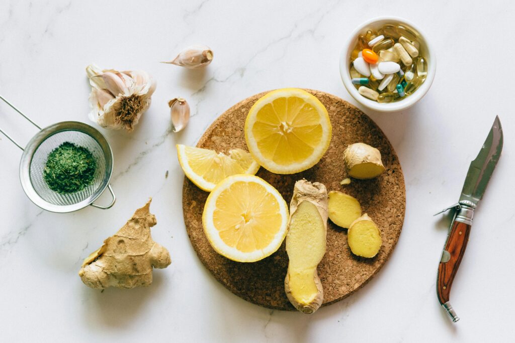 pexels-photo-7615477-7615477 Flat lay of natural remedies including lemon, ginger, and garlic alongside pills.